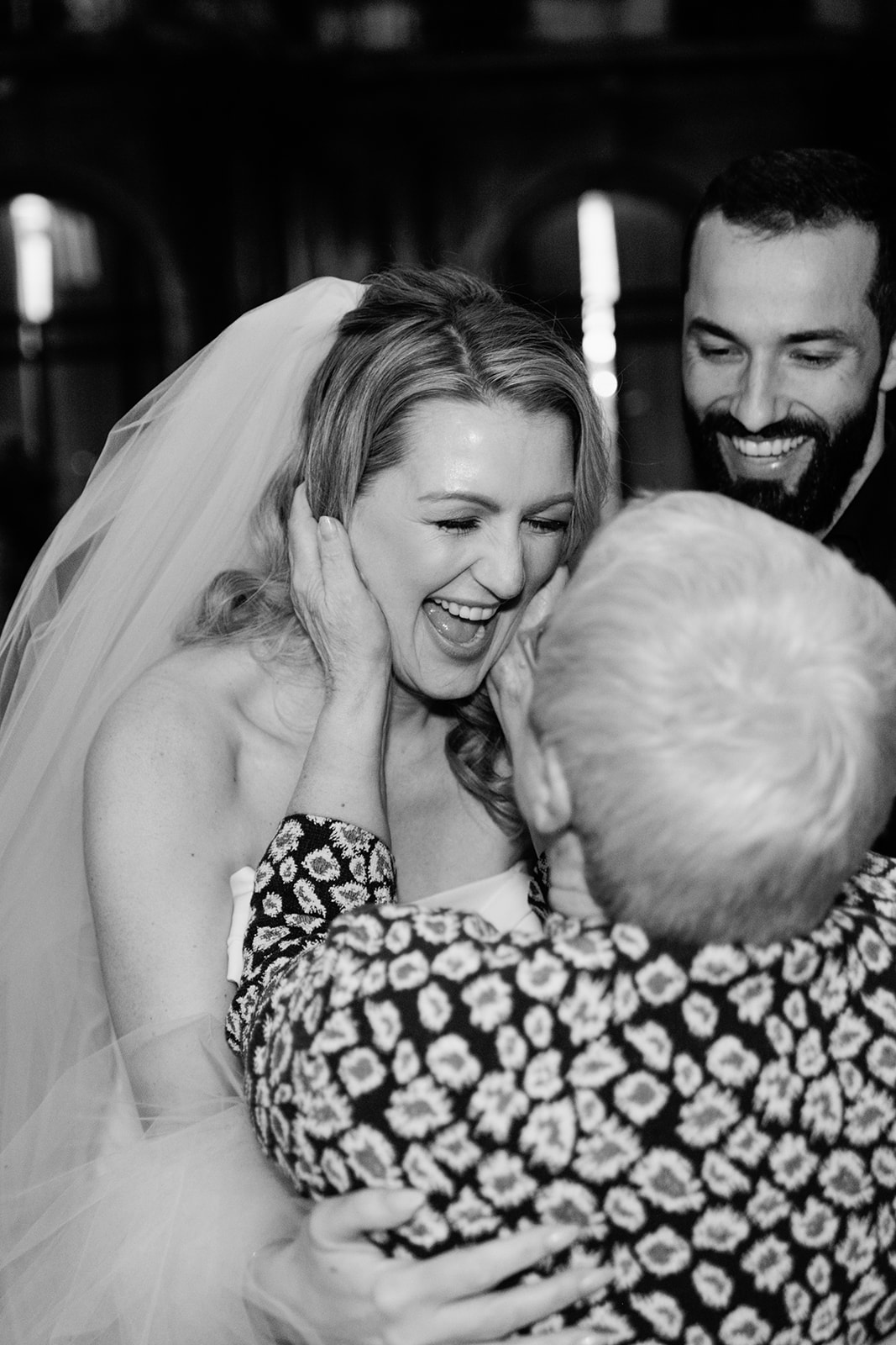 Bride laughing during a family embrace after the Plaza Athénée wedding ceremony